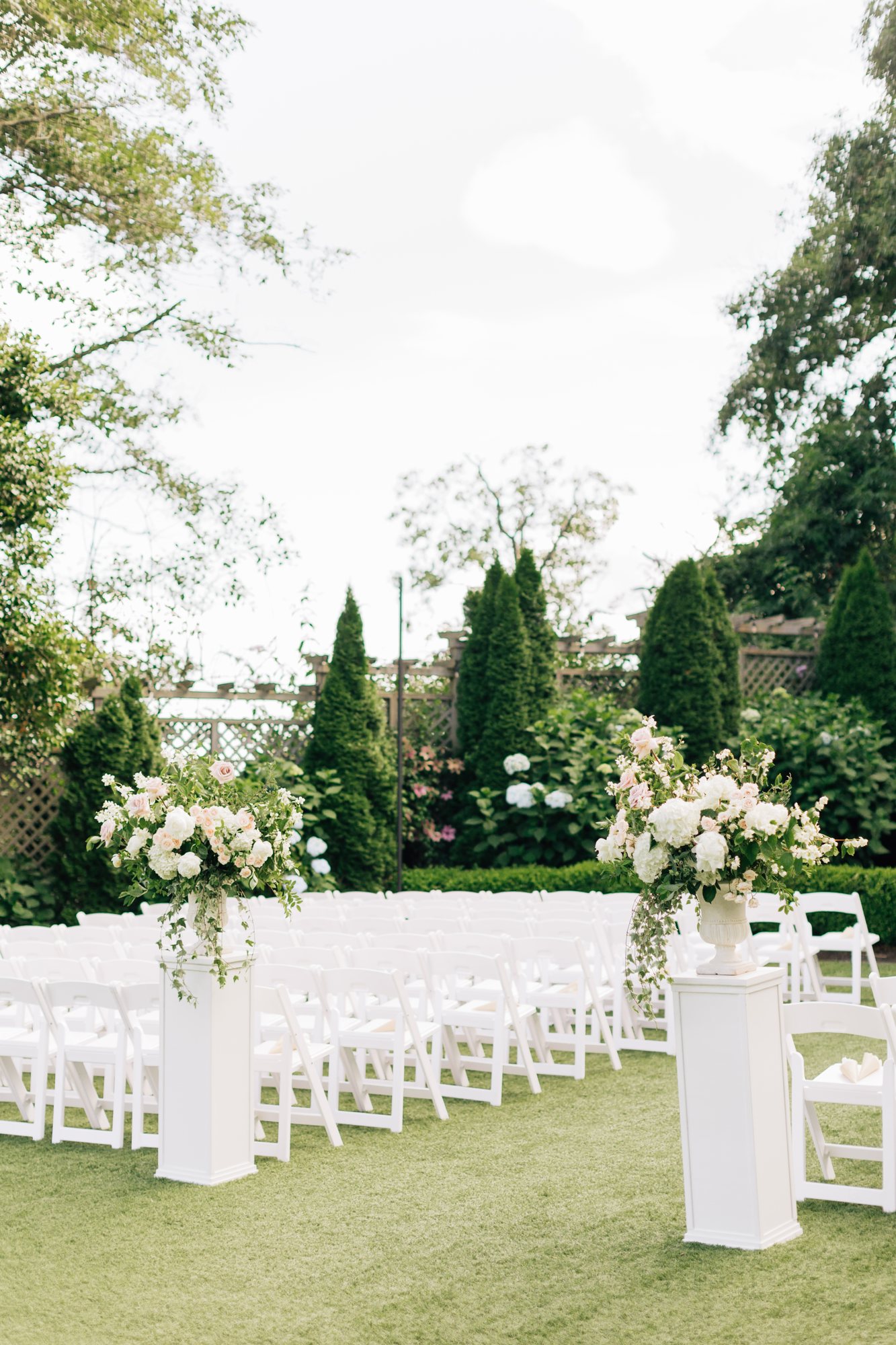 Garden ceremony aisle lined with white florals